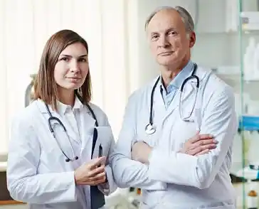 Deux professionnels de la santé, une femme médecin et un homme médecin en blouses blanches, posent dans un cabinet médical. Ils portent des stéthoscopes autour du cou, symbolisant le domaine médical et les soins de santé.